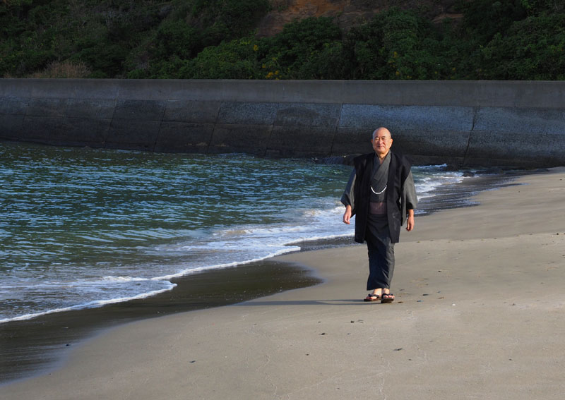 恋の浦の砂浜を歩く着物姿の和田爺