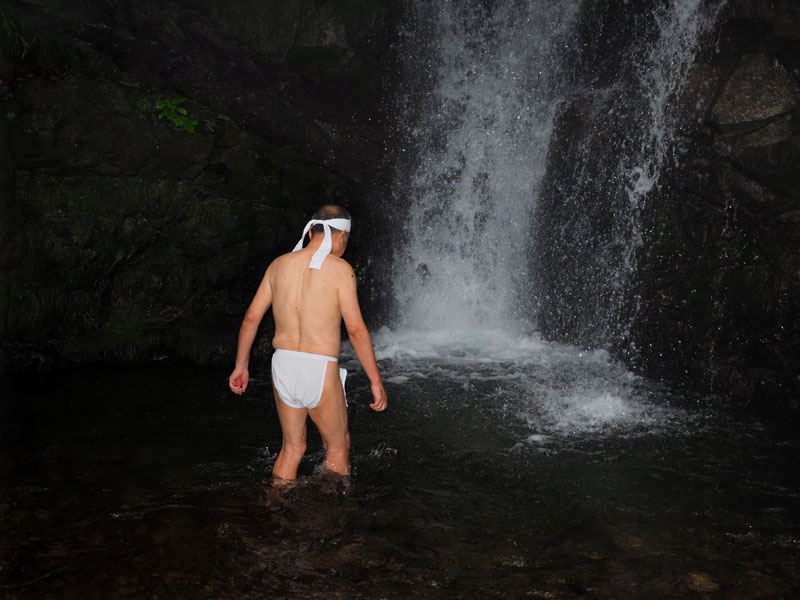滝の本流に向け滝壺の深さを測りながら慎重に歩を進める和田爺