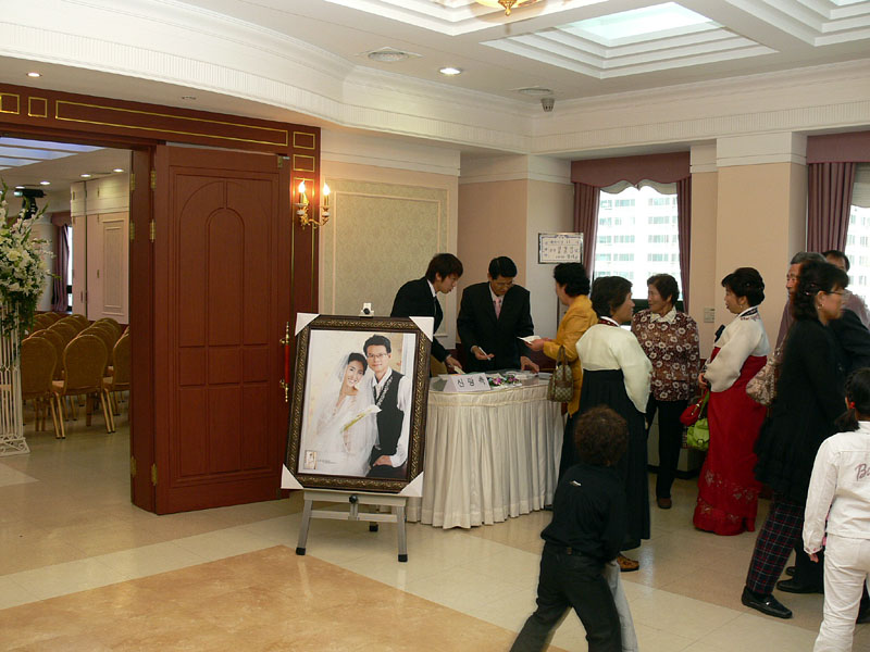 新郎新婦の大きな写真が飾られた結婚式場の受付