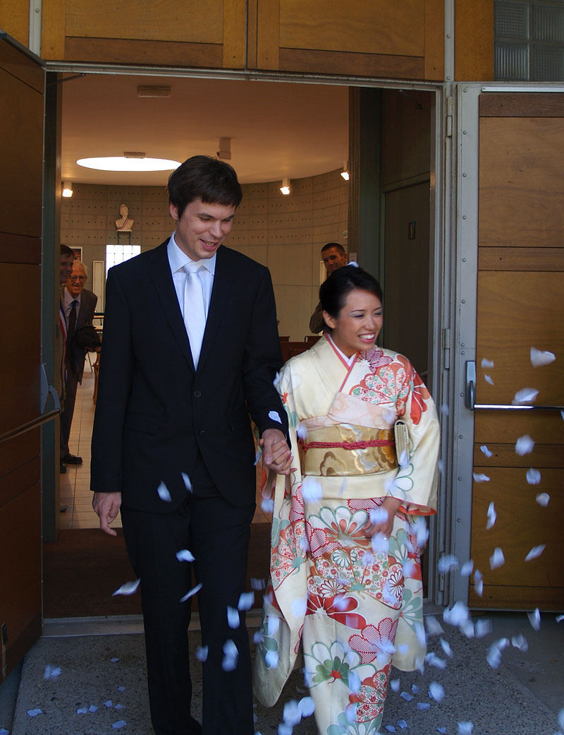 花吹雪で祝福を受ける新郎新婦
