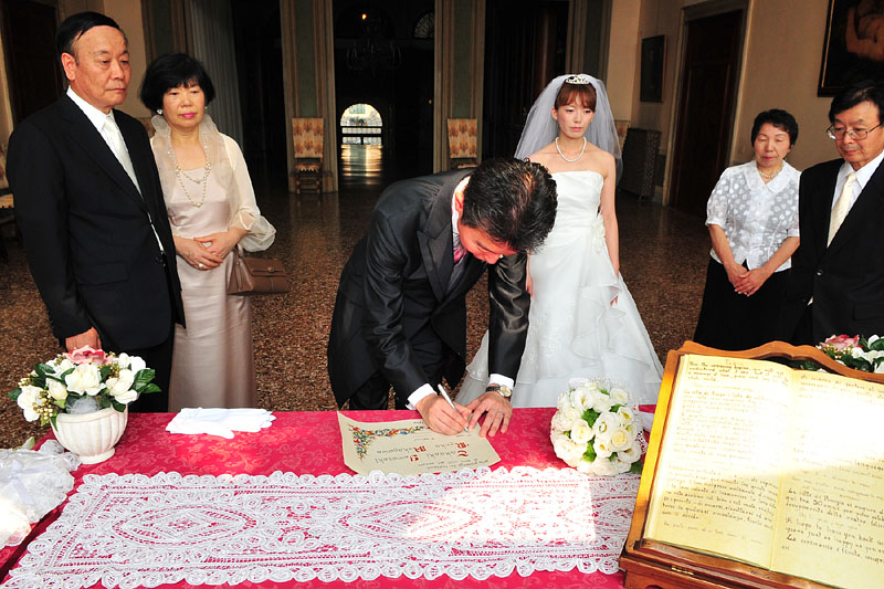 新郎新婦と両親が結婚証明書に署名