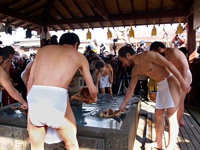 手桶で水を汲む
