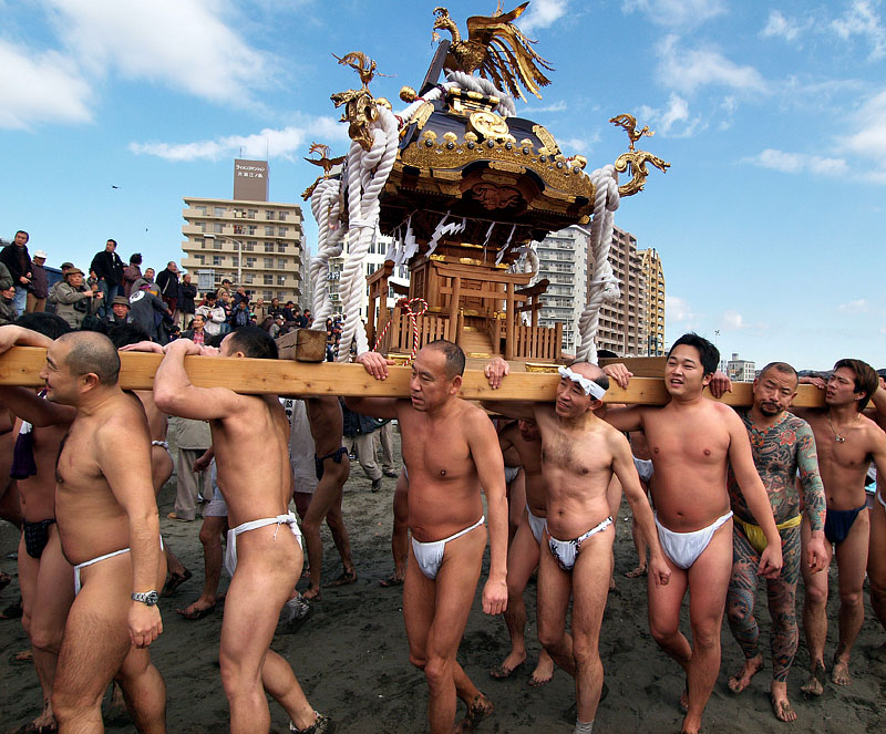 仲間と共に神輿を担ぐ