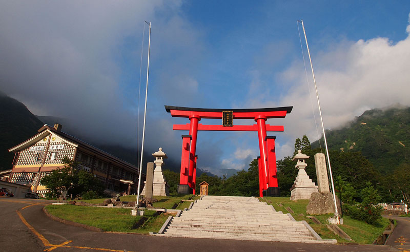 湯殿山神社本宮の参道入口に立つ巨大な赤鳥居と湯殿山参籠所
