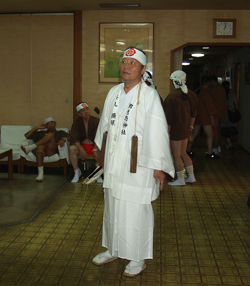 采配と拍子木を持つ祭礼頭領