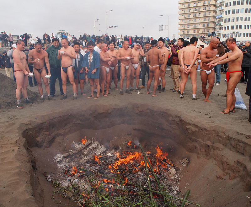 焚き火で暖を取る裸たち