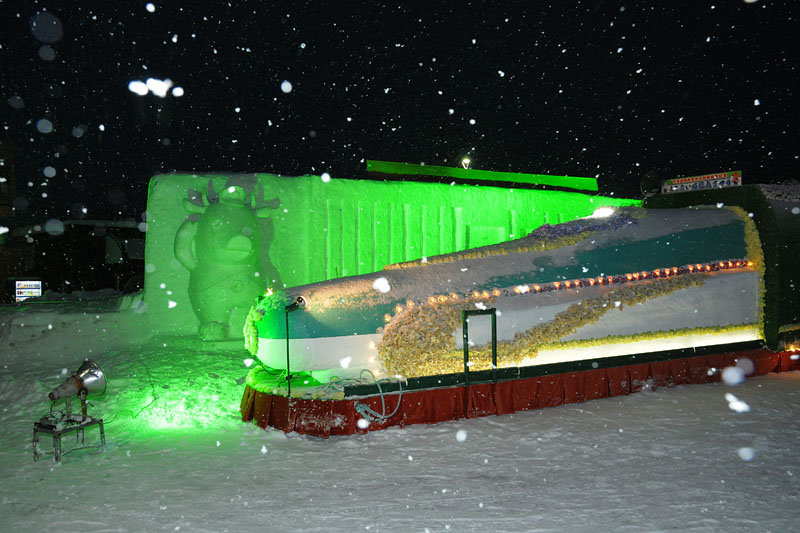 ライトアップされた木古内新幹線駅舎とキーコの雪像並びに北海道新幹線の山車