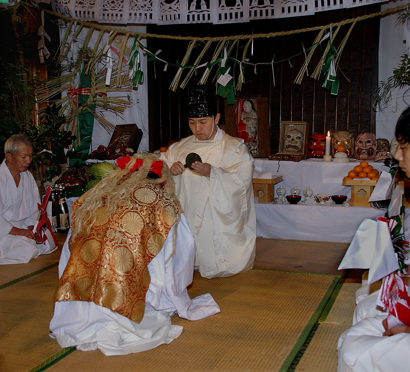 日月の鏡を手渡す神主