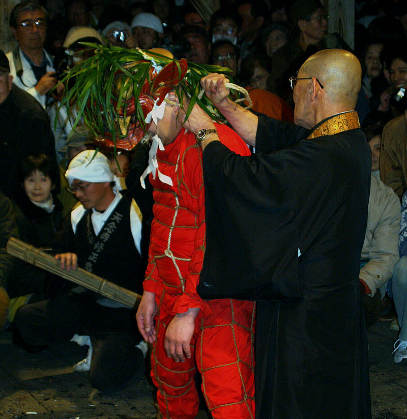 赤い鬼面を被った僧侶