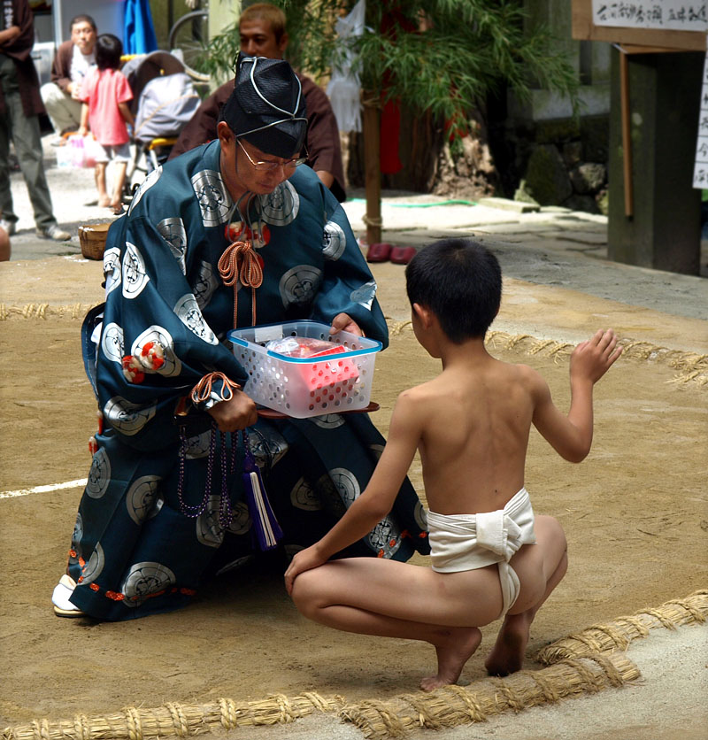 手刀を切って賞品を受け取る