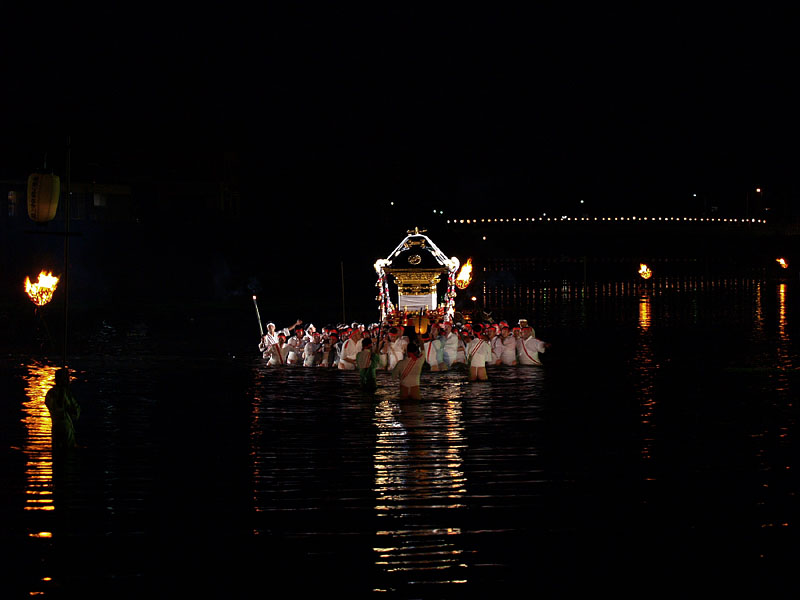 篝火の間を進む川渡神輿
