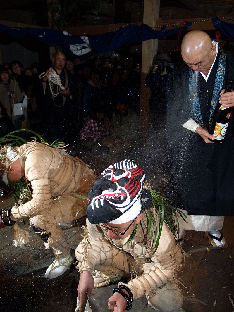 僧侶が酒を吹きかける鬼招き