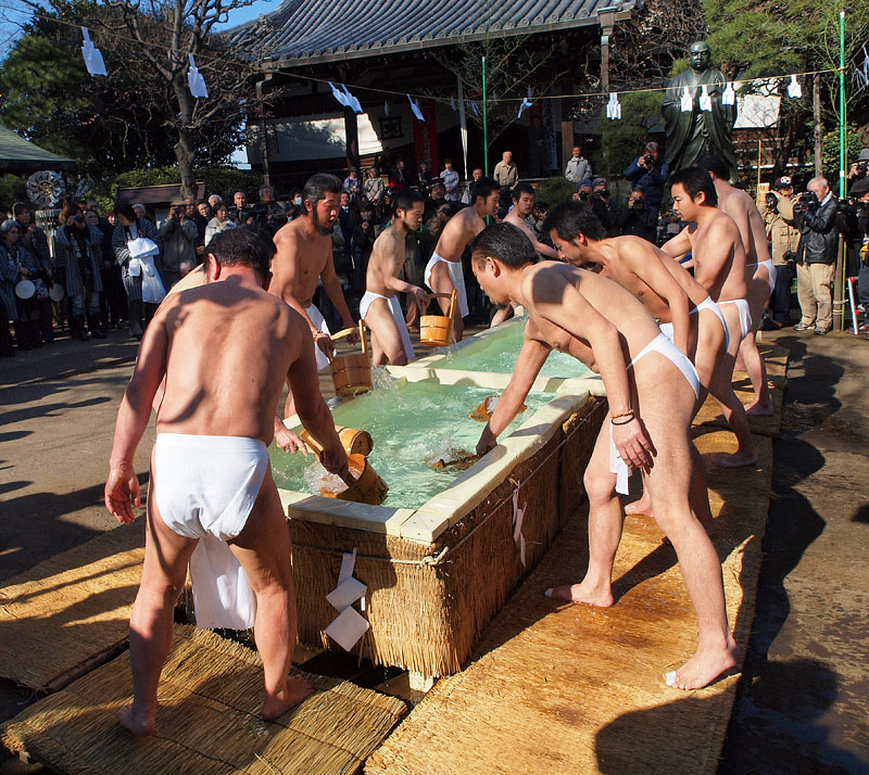 手桶で水を汲む