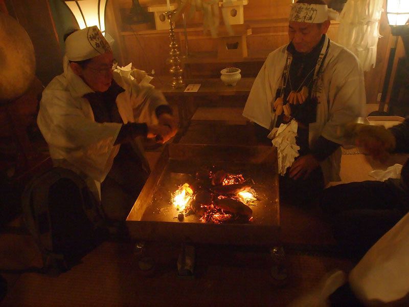 護摩の残り火で芋を焼く宮司 02:04