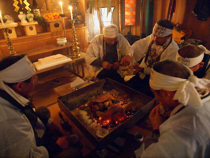 護摩台を囲んでお茶と焼き芋で一服する宮司と先達たち 10:54